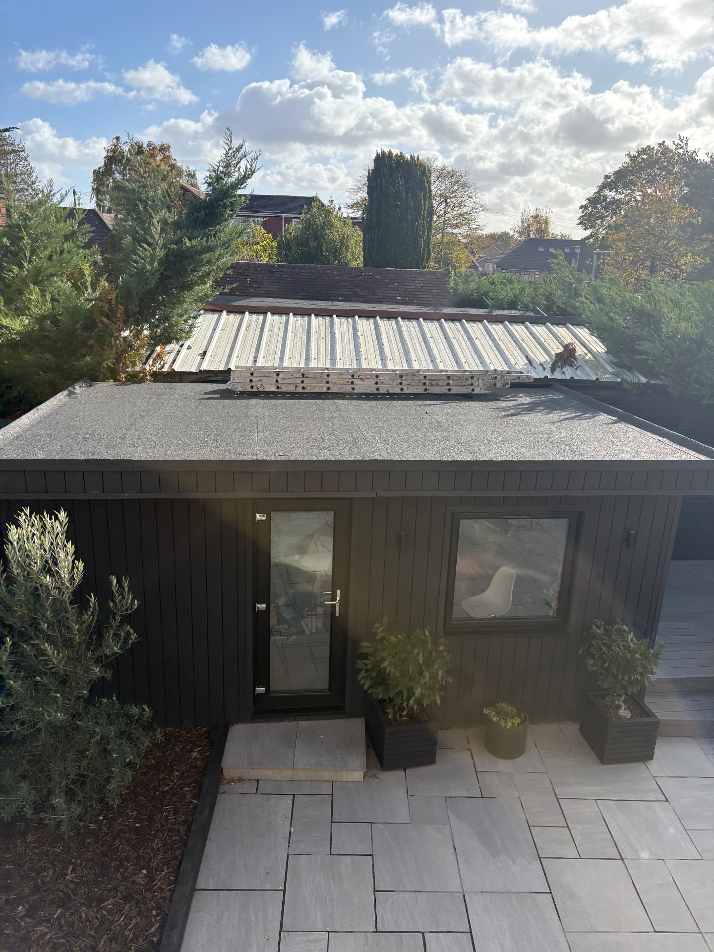 Felt flat roof on a timber-clad garden building
